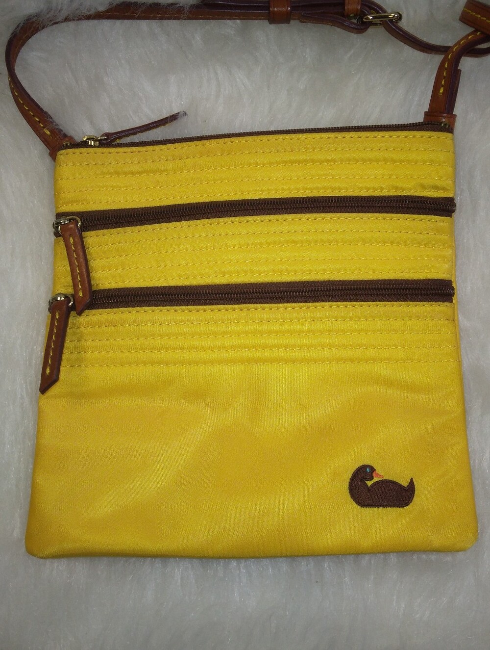 The Dooney & Bourke Nylon North South Triple Zip in yellow